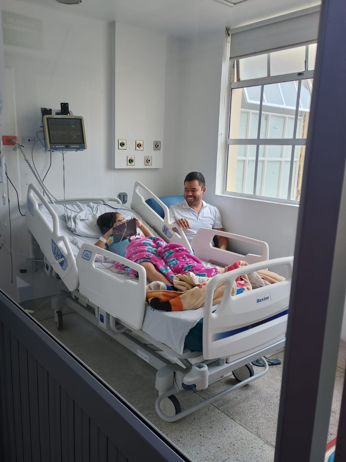 Una niña hospitalizada acompañada por su familia en la Sala Ana Frank.